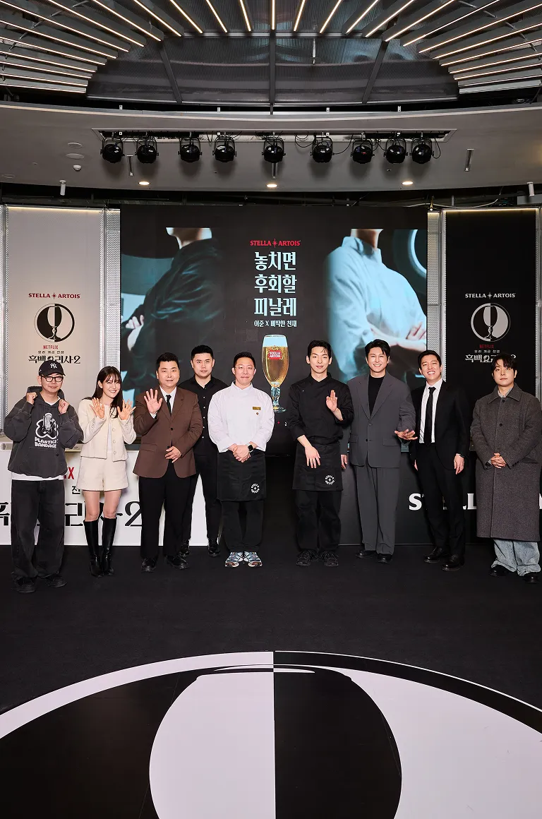피날레 이벤트에 참석한 셰프들과 게스트들이 스텔라 아르투아 포토존 앞에서 단체 기념 사진을 찍고 있습니다