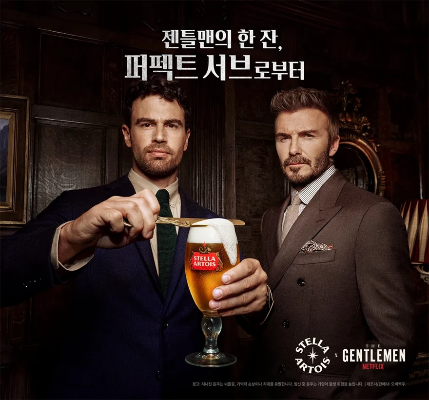 스텔라 아르투아 x 넷플릭스 〈젠틀맨: 더 시리즈〉시즌2 캠페인 - 정장 차림의 두 남성이 골드 스패출라로 스텔라 아르투아 챌리스 잔의 거품을 정리하는 퍼펙트 서브 메인 비주얼