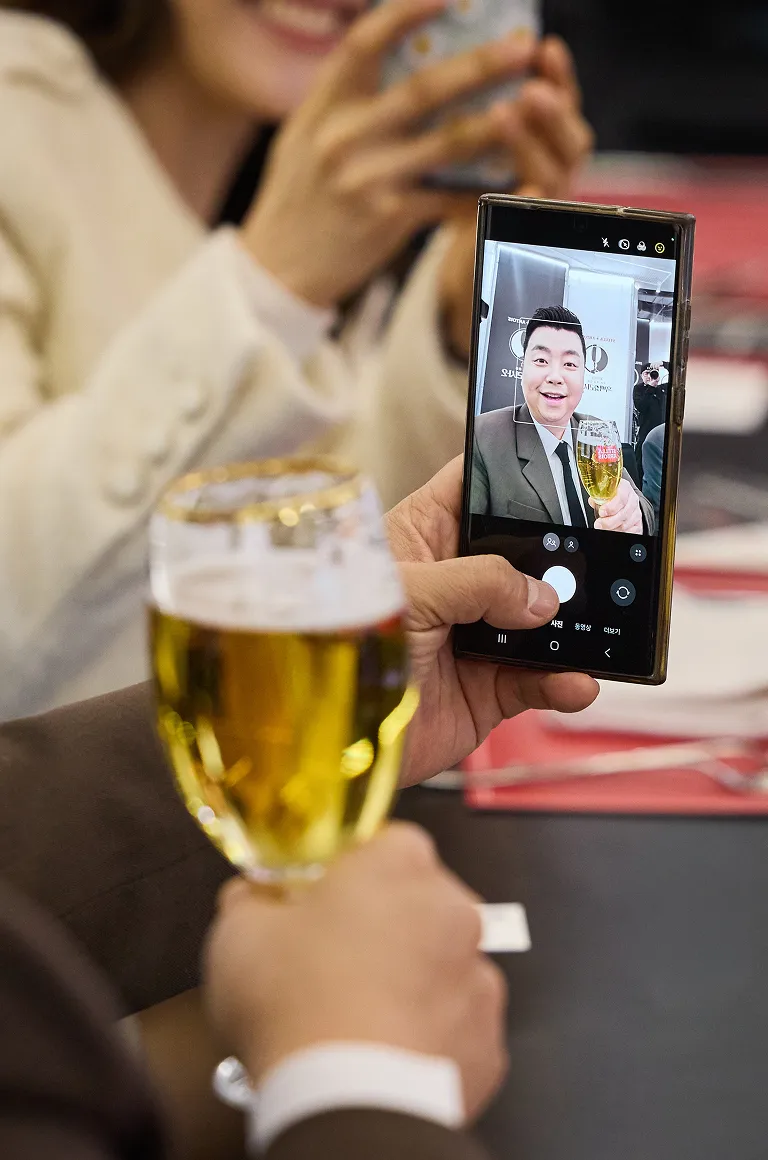 누군가의 휴대폰 화면에 정호영 셰프의 영상통화 모습이 보이고, 옆에는 스텔라 아르투아 생맥주가 놓여 있습니다