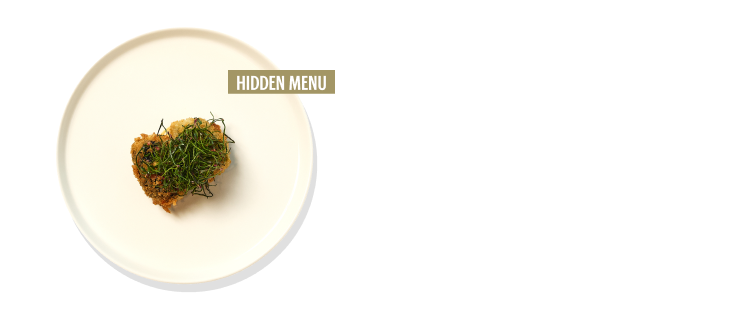 히든 메뉴로 하얀 접시에 하트 모양 음식 위에 각종 식재료로 만들어진 미스터리 음식이 있습니다